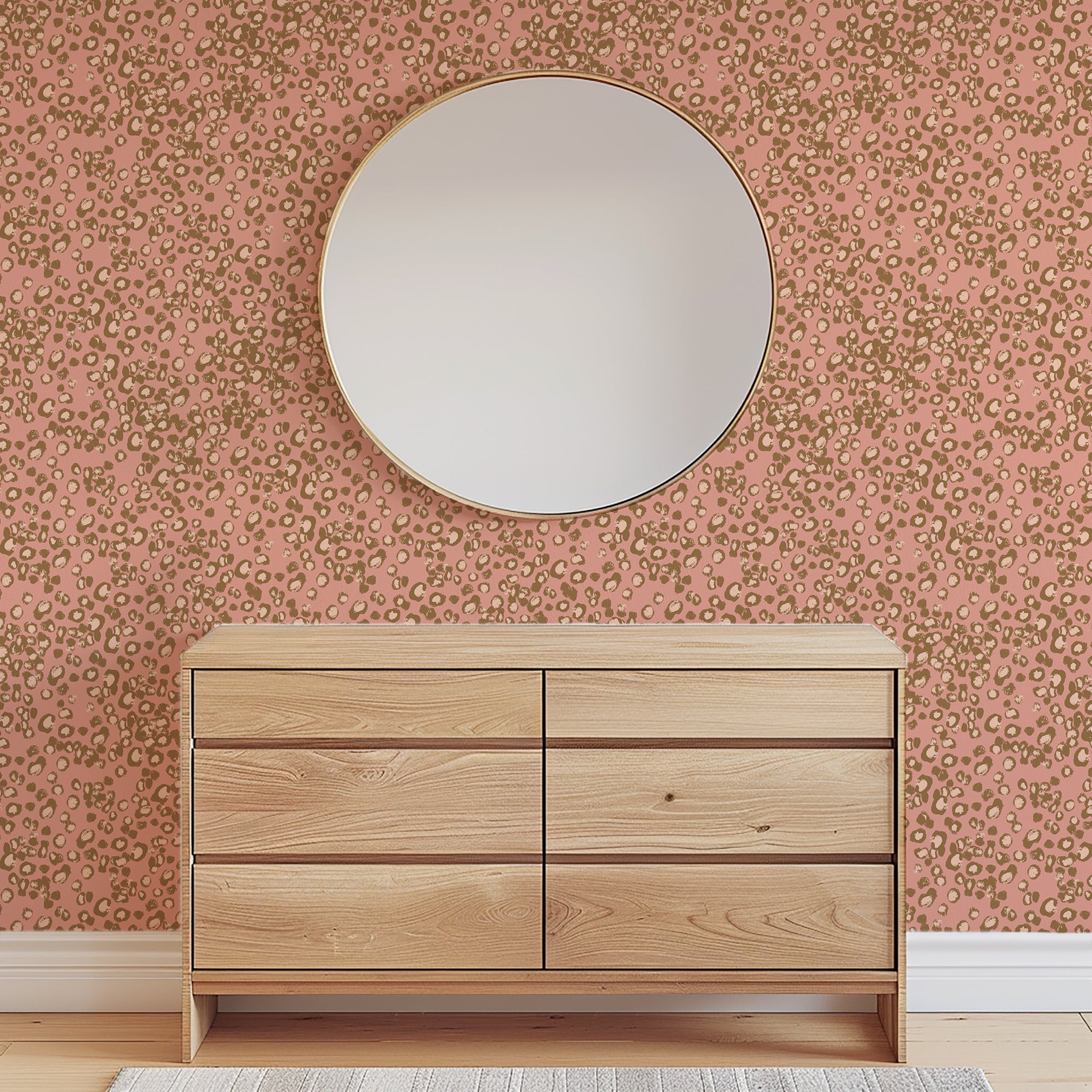 Wooden dresser with a round mirror against a patterned wall.